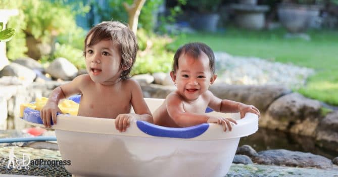 Two kids in a bathtub outside