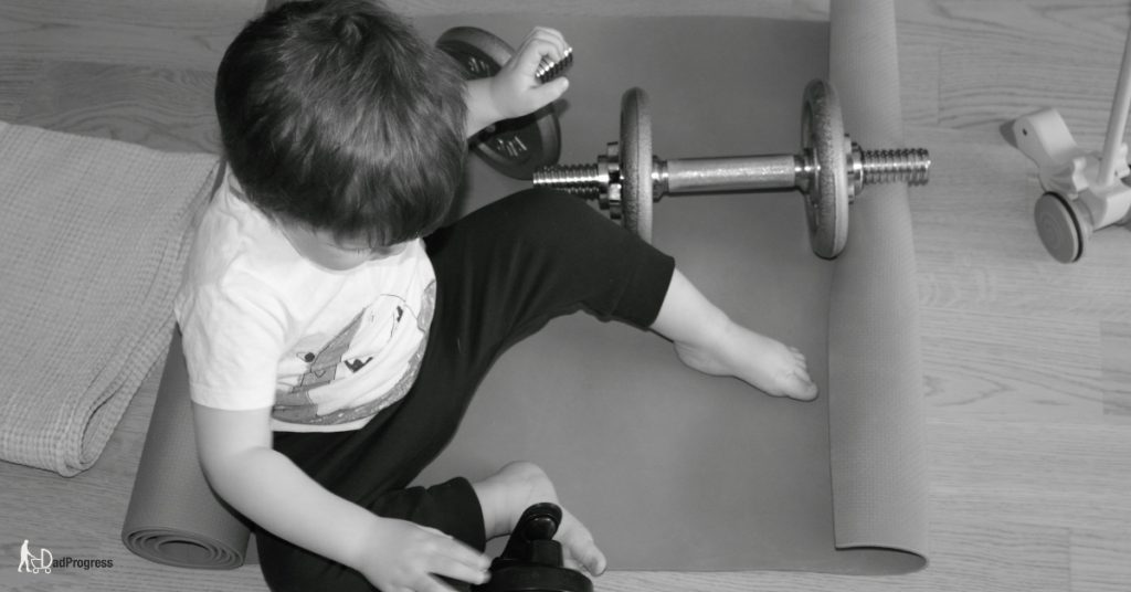 Toddler On a Gym Mat With Dumbbells