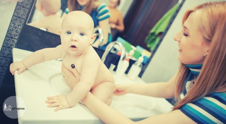 Mother Washes A Baby In A Sink Before Diaper Change