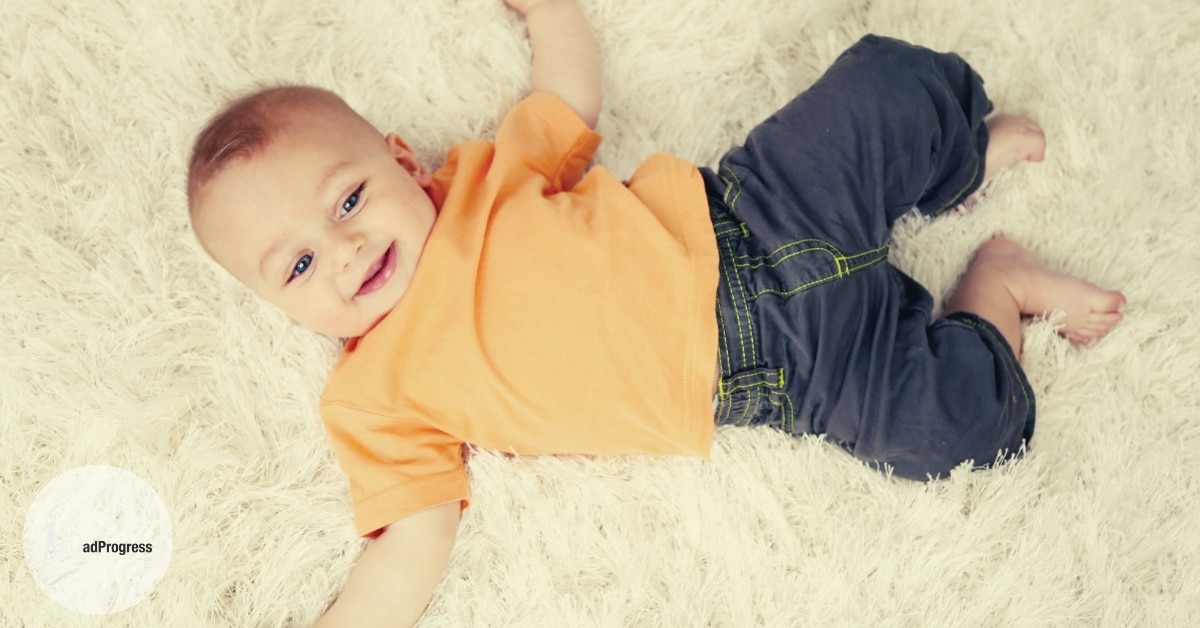 Best Nursery Rugs Featured Image- about one-year-old boy on a nursery carpet smiling