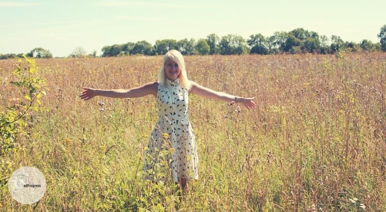 Blond smiling woman on a meadow in summer