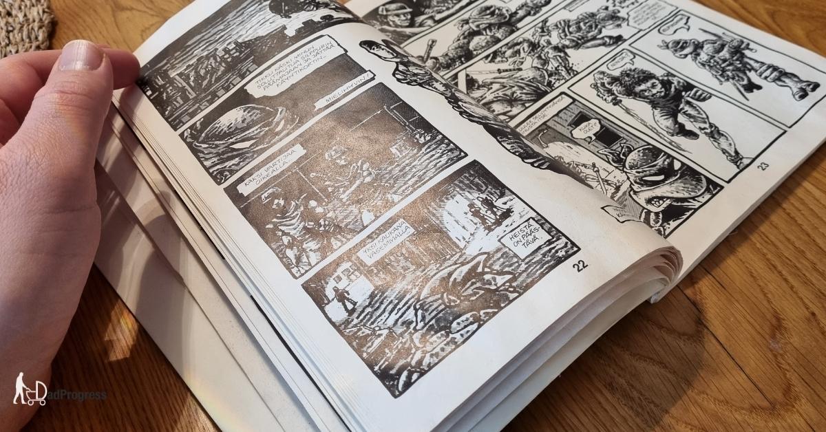 A black-white ninja turtles comic book is open on a wooden table