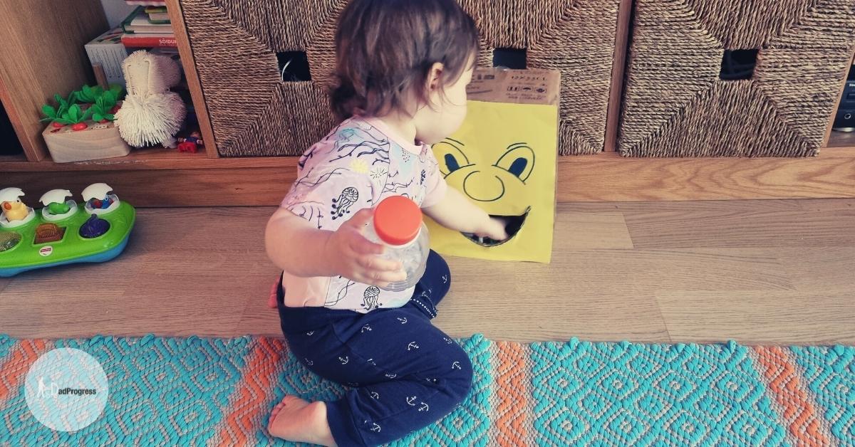 Young toddler is feeding the monster on a wooden flooring