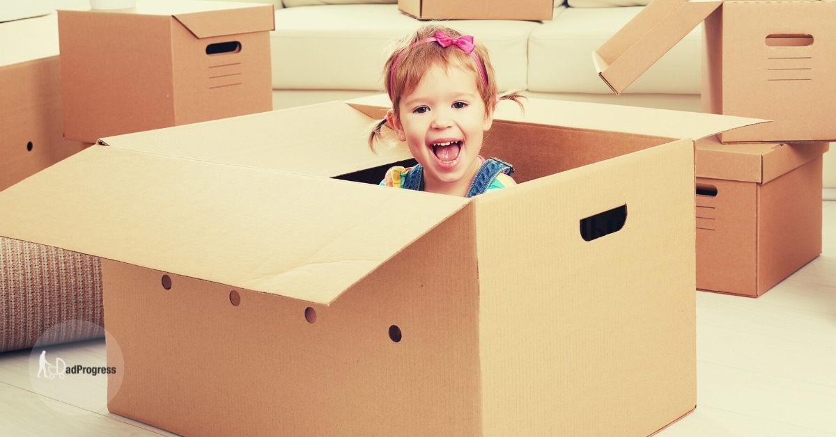 Best Pack and Play Featured Image- Girl Sitting in a cardboard box and smiling
